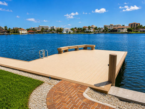 New dock construction with built-in bench on a blue waterway. Built By Collier Seawall and Dock LLC.