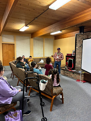 Picture of a man speaking to children and their families