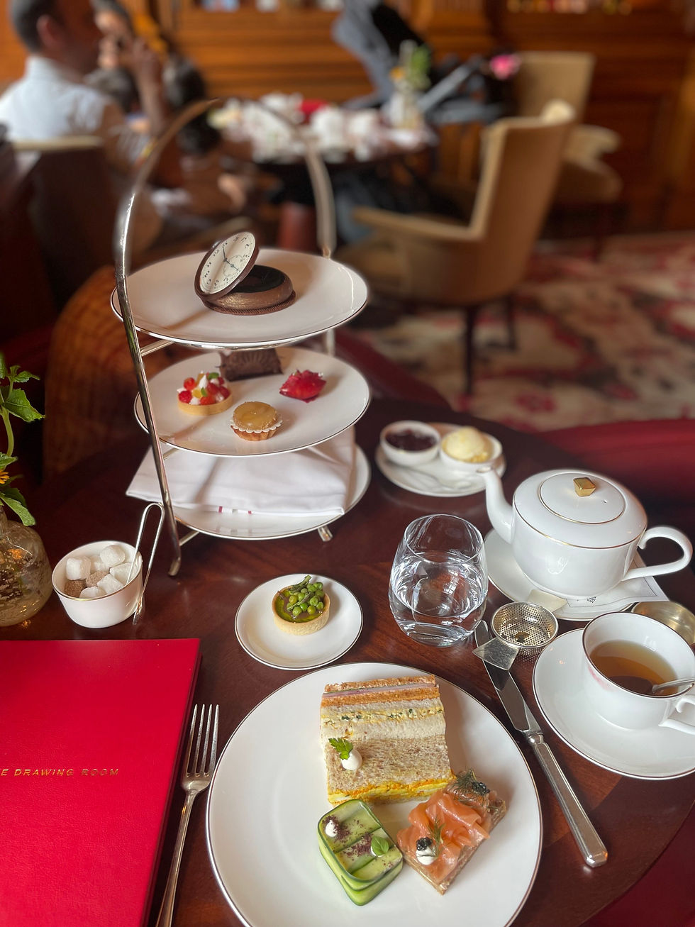 A delightful afternoon tea experience at The Raffles Hotel, featuring an elegant spread of sandwiches, pastries, and a pot of tea set against the classic ambiance of The OXO in Whitehall, London.