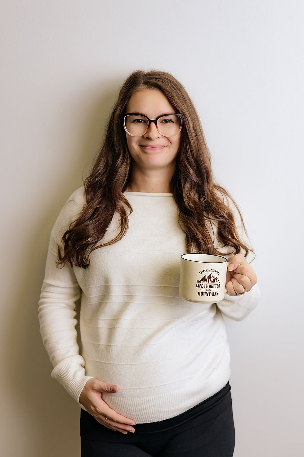 Midnight Mamas Breastfeeding Counselor Sienna holding a coffee and her pregnant belly