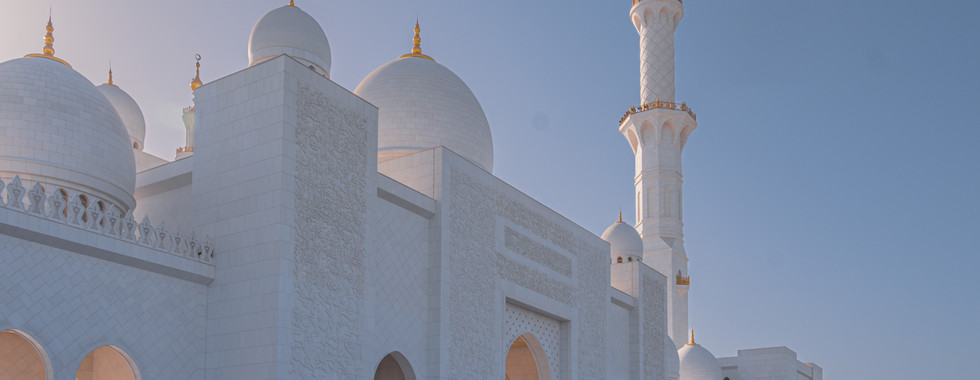 Vue extérieure de la mosquée Sheikh Zayed à Abu Dhabi, sous un ciel dégagé.
