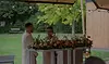 Un couple lors d'une cérémonie de mariage interculturelle, la mariée prend la parole devant un pupitre décoré de fleurs.
