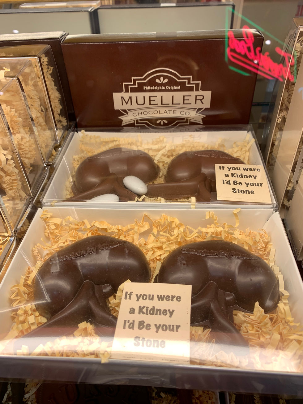 Chocolate kidney-shaped candies in a Mueller Chocolate Co. display, with signs reading If you were a Kidney I’d Be your Stone