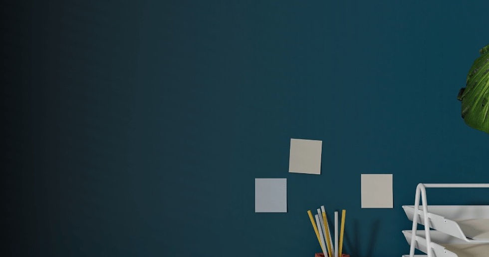 Blank workflow notes arranged on a blue office wall beside a desk organizer and plant