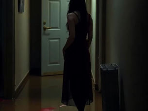 A woman in her home about to go check her door.
