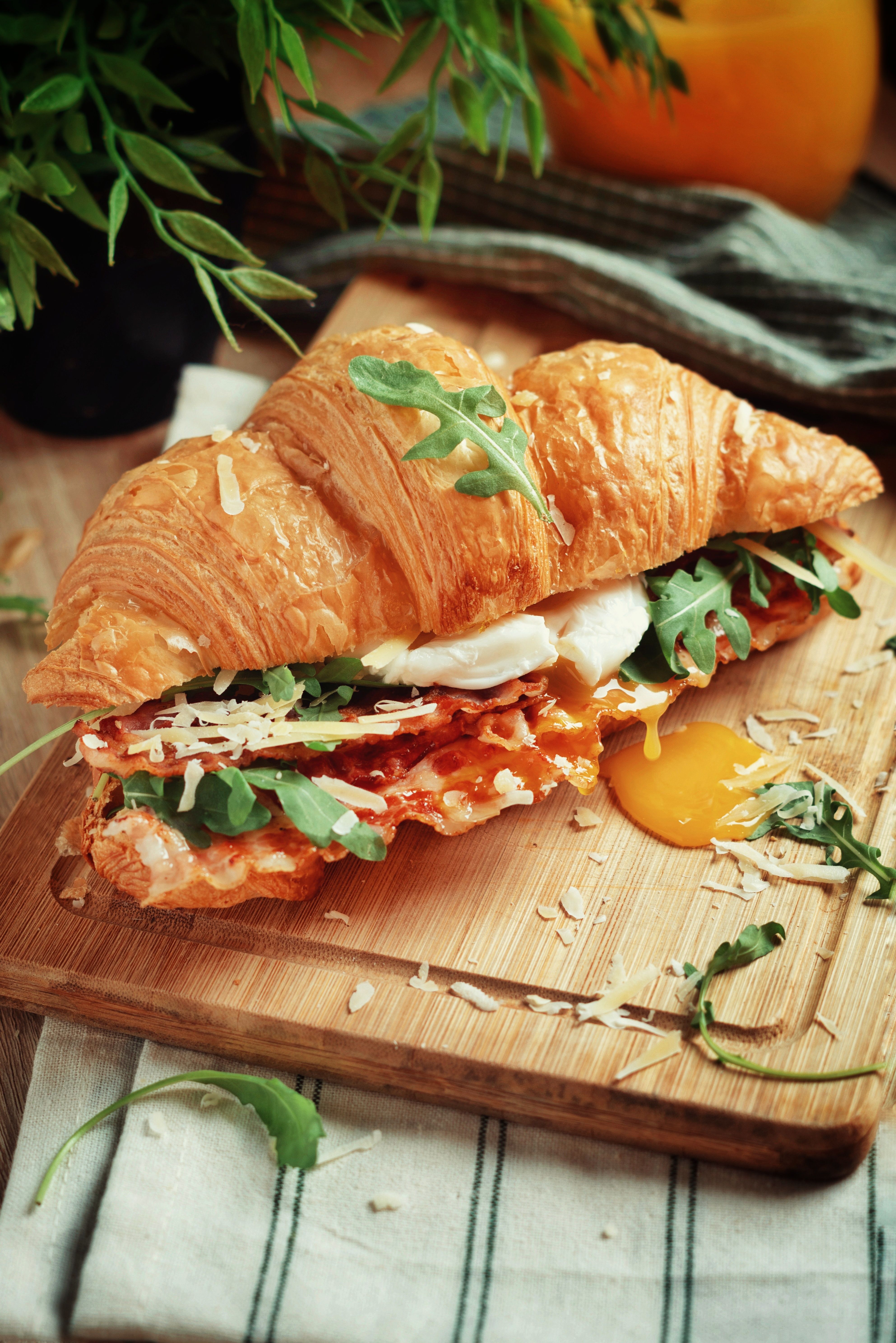 Breakfast croissant sandwich with egg and greens; illustrative photograph