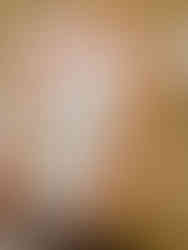 A unicorn is being painted on a piece of paper by a child.