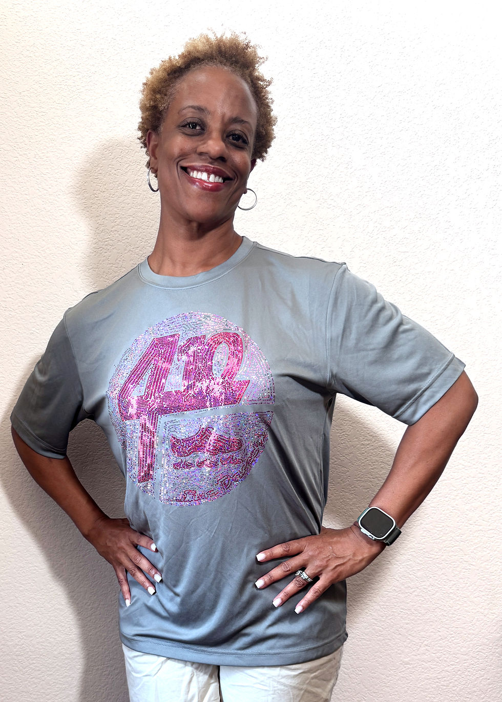 Close-up of 410 Line Dancers pink rhinestone logo on gray shirt.