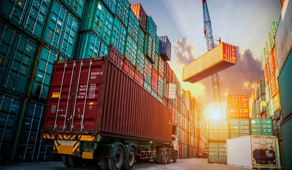 Operación portuaria al atardecer donde una grúa eleva un contenedor sobre un camión entre pilas de contenedores, con luz solar filtrándose entre las estructuras.