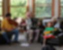Three older gentlemen playing music with a small child.