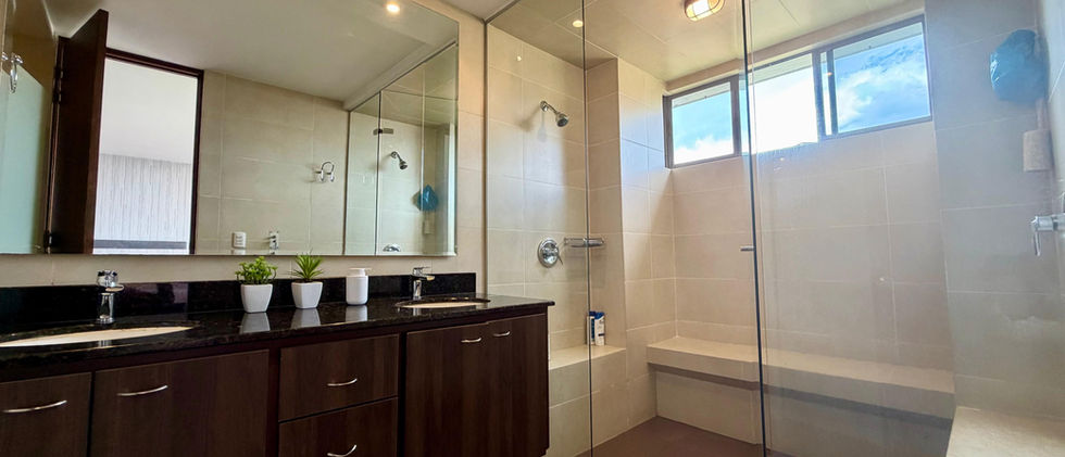 Baño con ducha en vidrio, mesón y acabados modernos, apartamento Guayacanes de la Calera Medellín