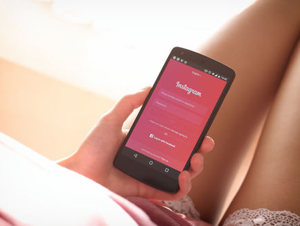 Woman using a smartphone, illustrating fashion creators’ more personal Instagram strategy