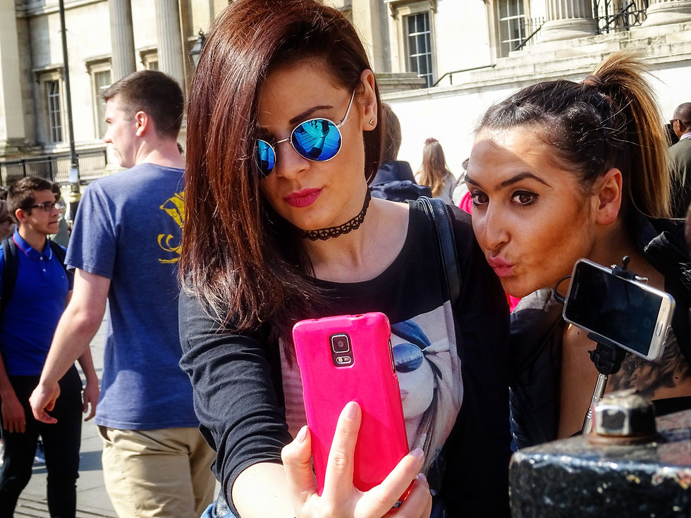 A woman holding a phone close while taking a selfie, illustrating how camera distance changes facial proportions