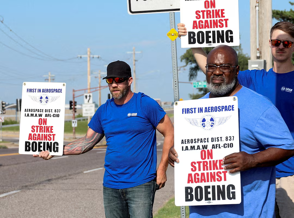 Workers hold signs during a walkout by members of the International Association of Machinists and Aerospace Workers (IAM) over contract negotiations, outside Boeing company's facility, in Berkeley, Missouri, U.S., August 4, 2025. REUTERS/Lawrence Bryant