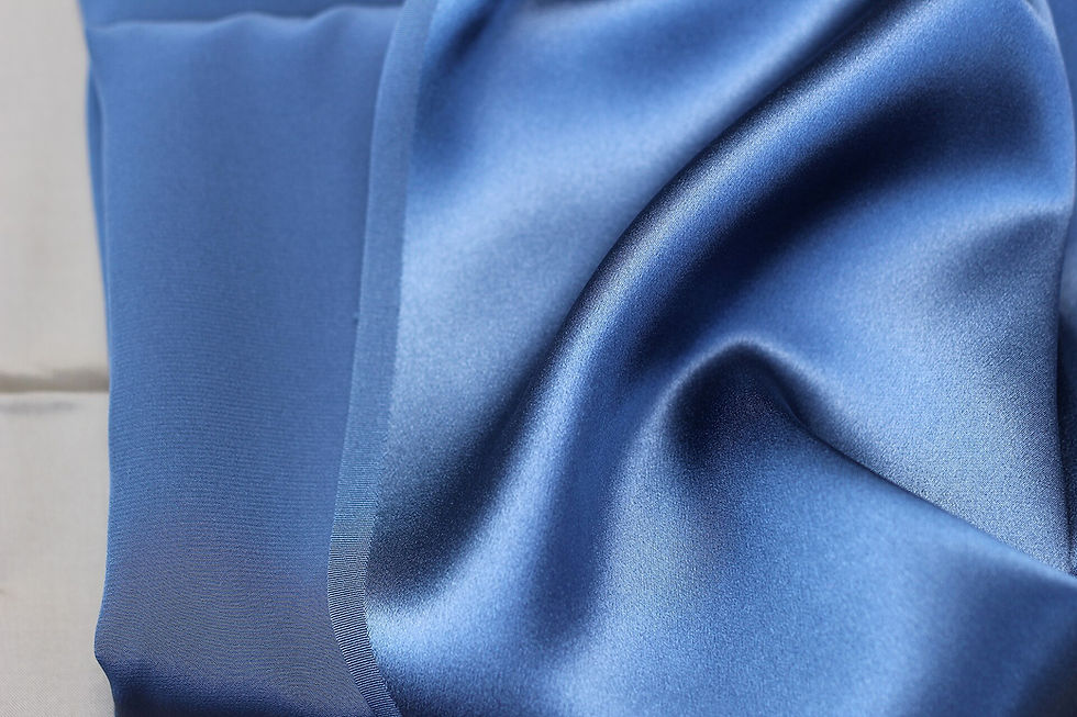 Blue silk charmeuse showing the sheen and drape shoppers should examine before buying satin pants