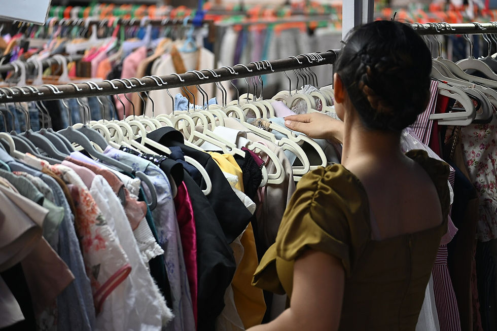 A shopper browsing a crowded clothing rack while considering which pieces will earn repeated wear
