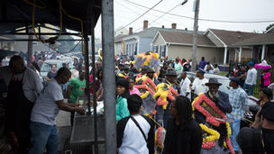 Dancers and brass musicians moving through a New Orleans second-line parade