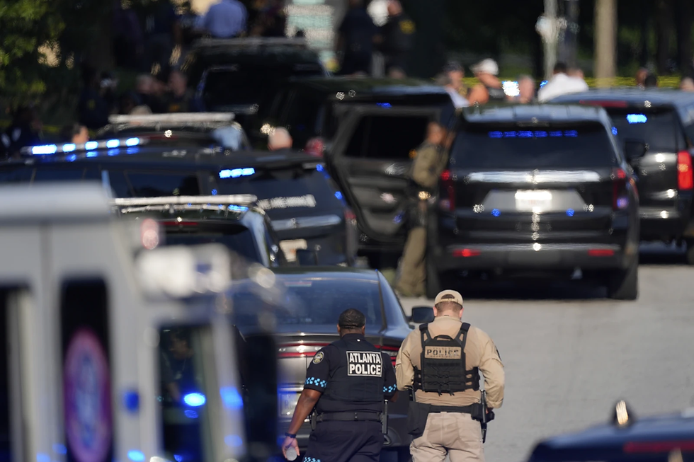 Police officers walk near the scene of shooting at the Emory University in Atlanta on Friday, Aug. 8, 2025. (AP Photo/Mike Stewart)