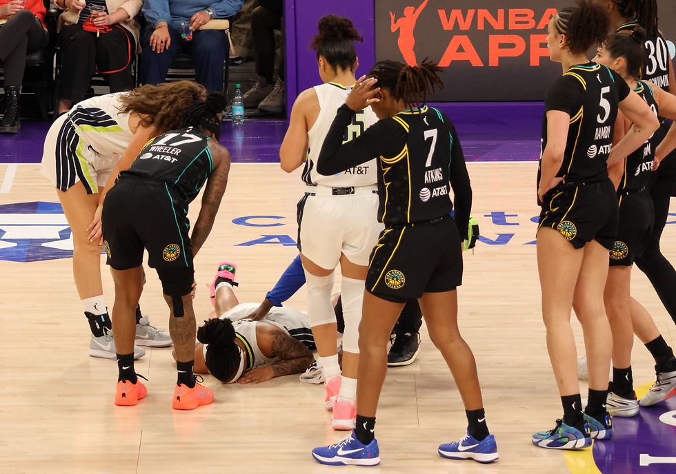 Wings and Sparks players surround Aziaha James who went down with an injury during Friday's game. Photo by Jackie Rae