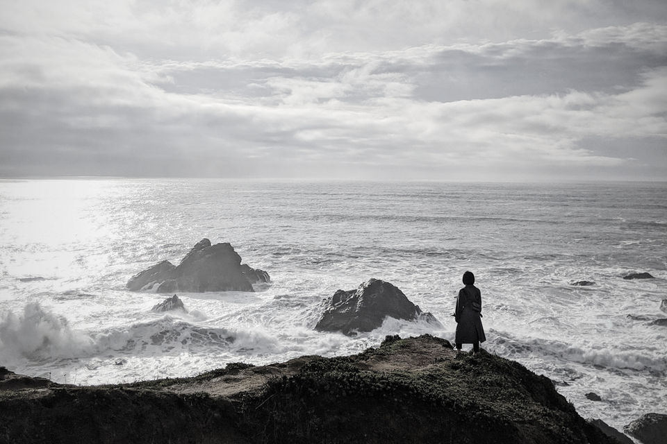 Woman overlooking waves at Goat Rock, CA