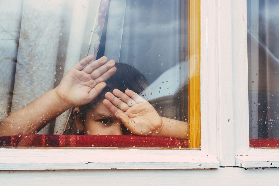 Child pressing hands against a rainy window, representing complex trauma and childhood CPTSD