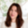 Photo of a  young white woman with brown hair and green eyes wearing a white sweater