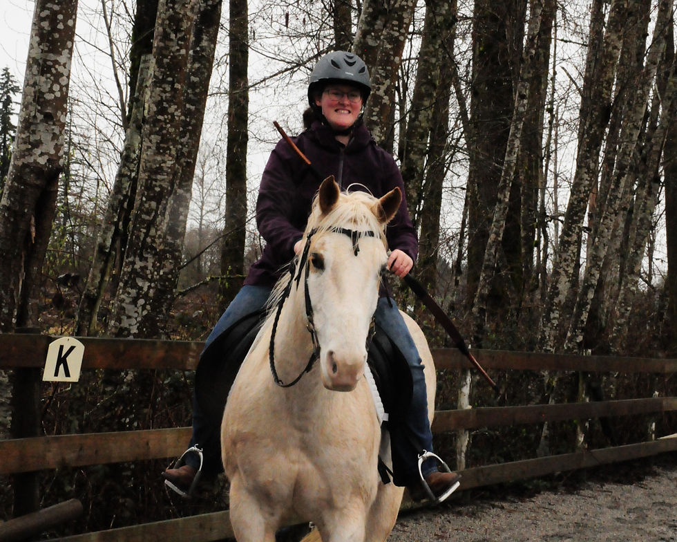 Rider on palomino horse holding a bow, with a big smile.