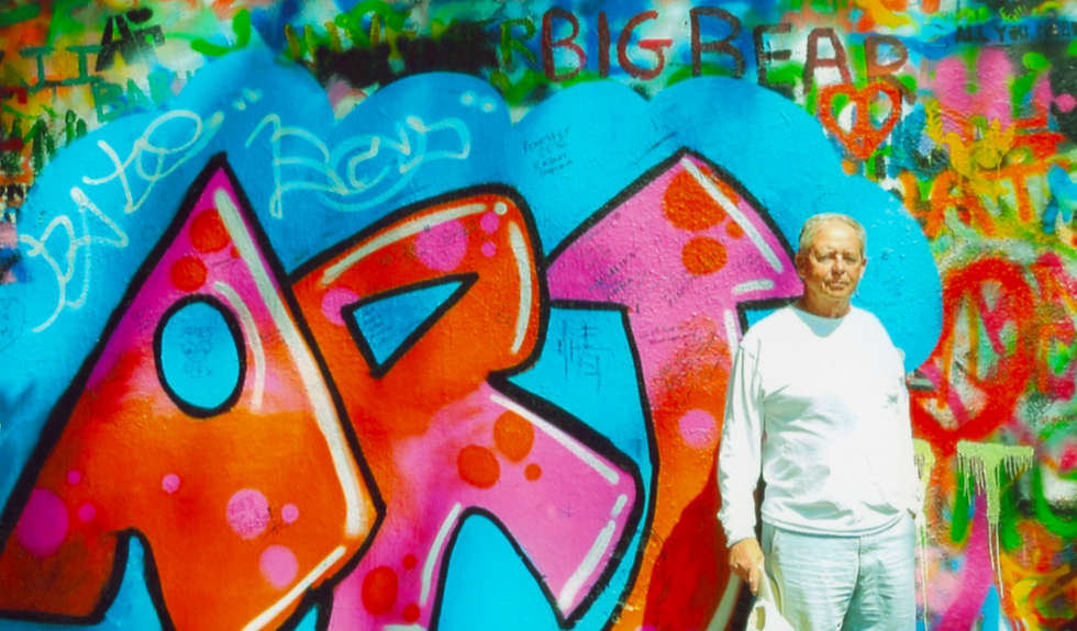 Author Joseph Cavanaugh in front of the John Lennon's Wall