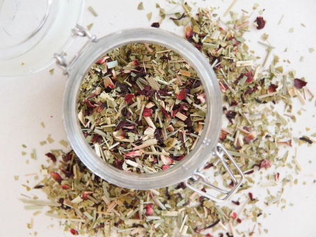 an image of dried out fruits, herbs and leaves creating a herbal tea blend