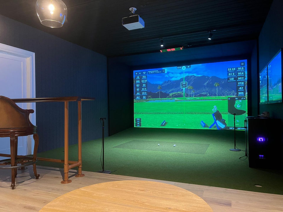 Custom-built golf simulator setup in dark feature room with putting green and AI-powered swing data on screen – Golfsim Australia residential install