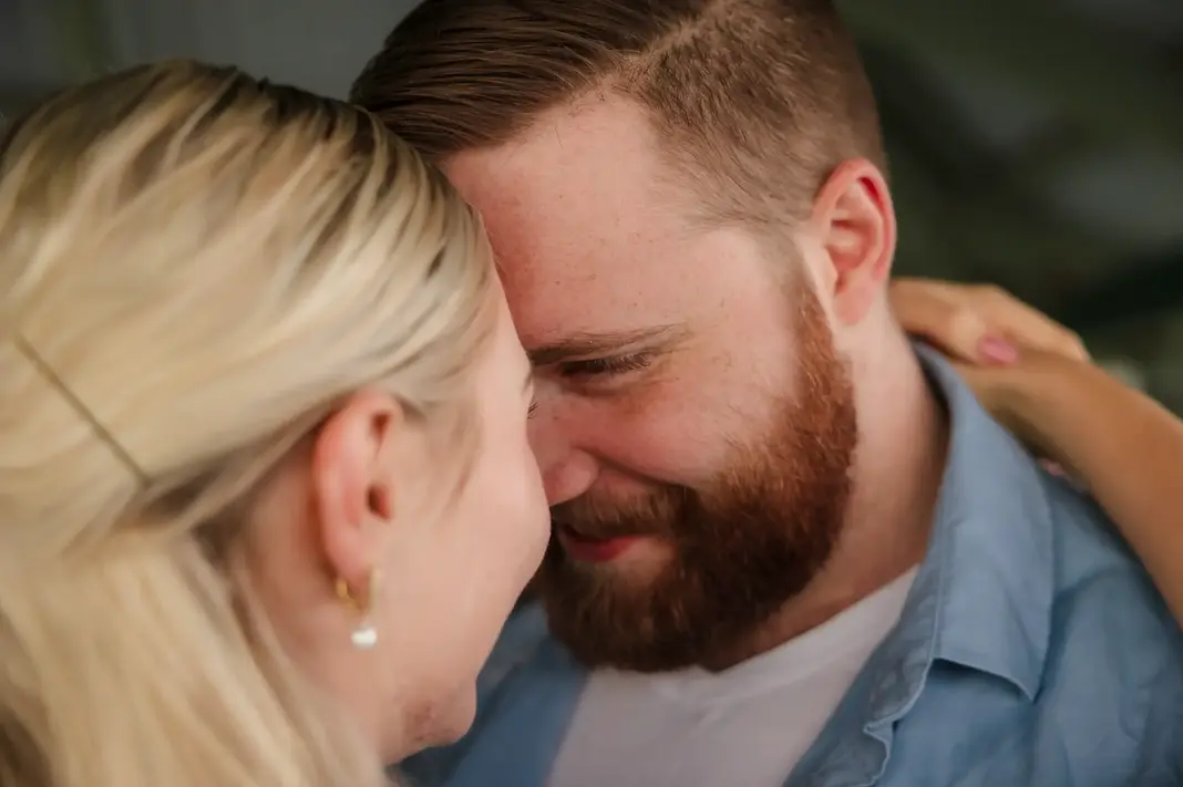Close-up of Faith and Alex smiling with foreheads touching and eyes locked during their engagement shoot at Lake Monger.