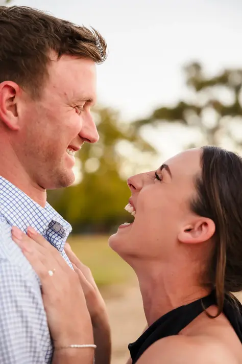 Baleigh and Kailym laughing together in a close-up moment during their engagement session at Matilda Bay Reserve, with her hands resting on his chest.