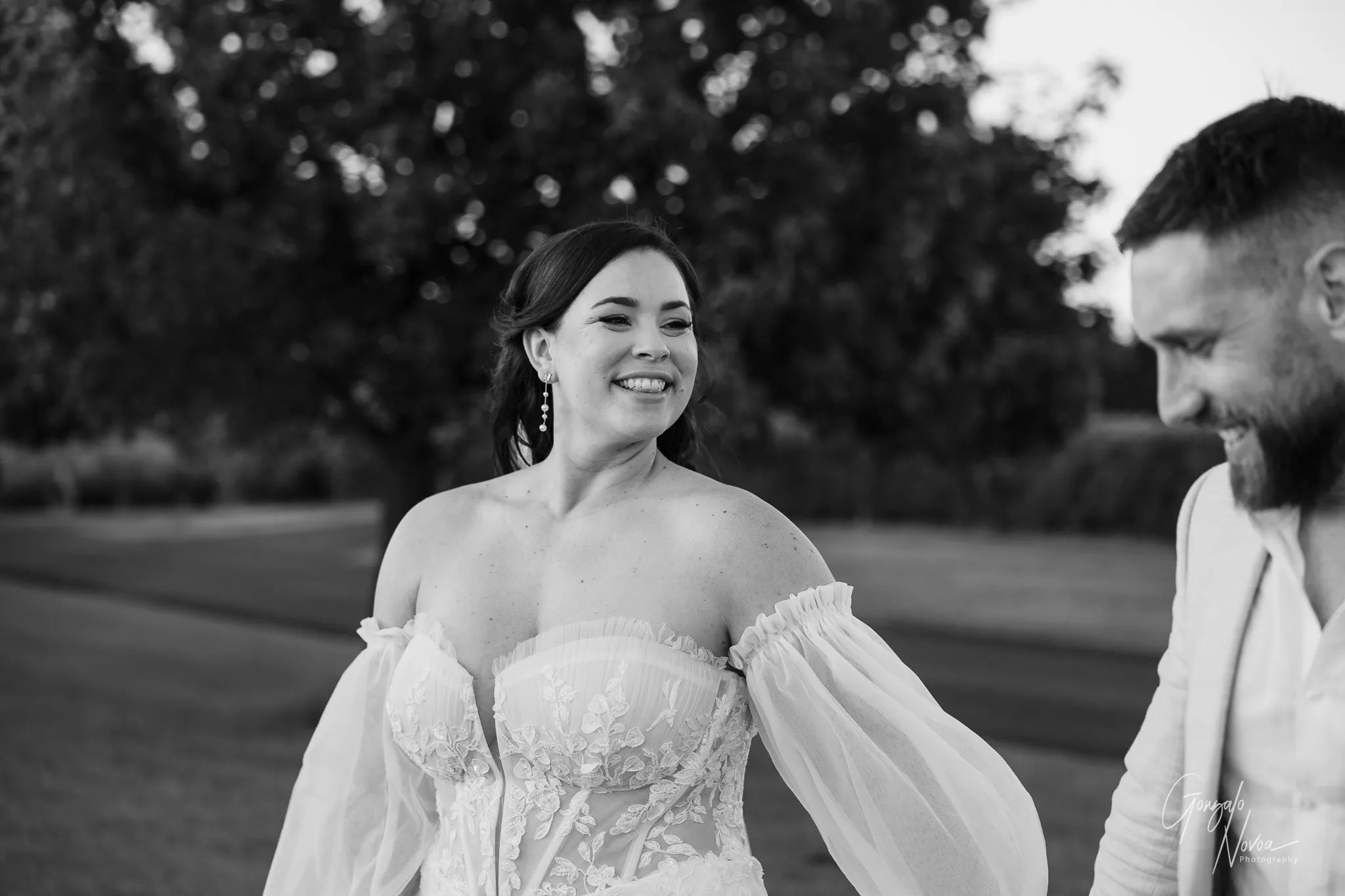 Close up of the bride smiling at the groom as they walk hand in hand outdoors