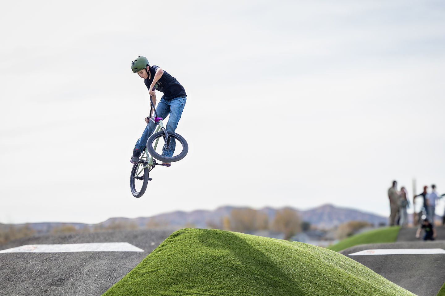 Teen doing jump on bike at bike park