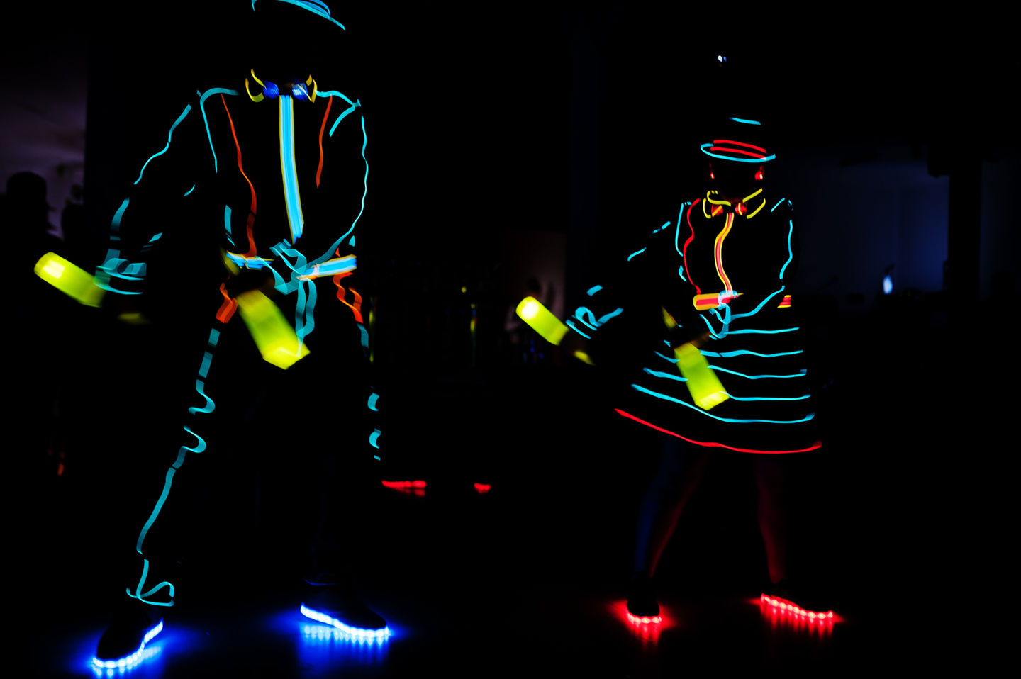 Two people dancing in glow in the dark outfits
