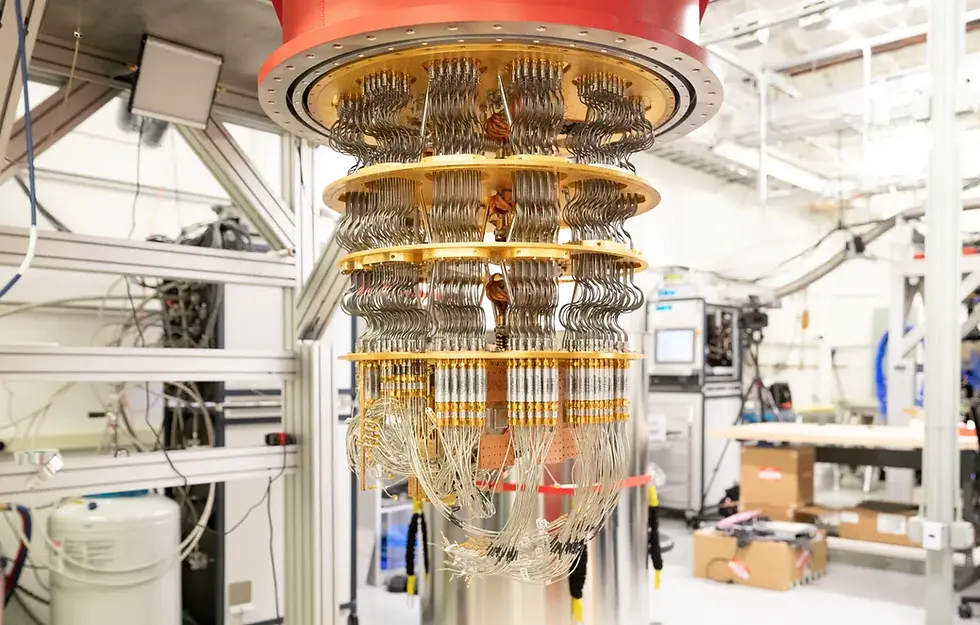 Quantum computer in a lab setting, with gold wires and circular layers. Background shows equipment and boxes, creating a high-tech atmosphere.