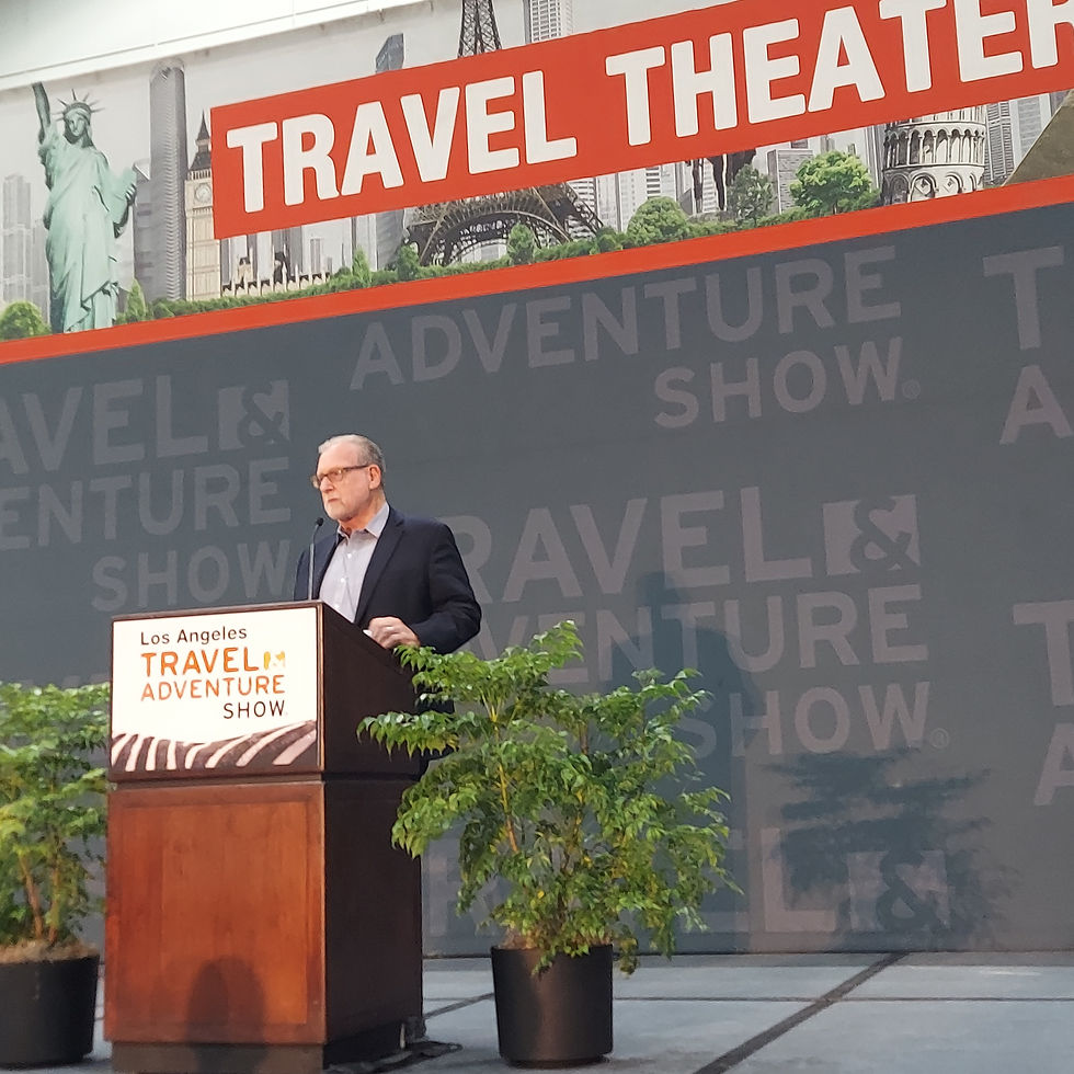 Peter Greenberg standing at a podium