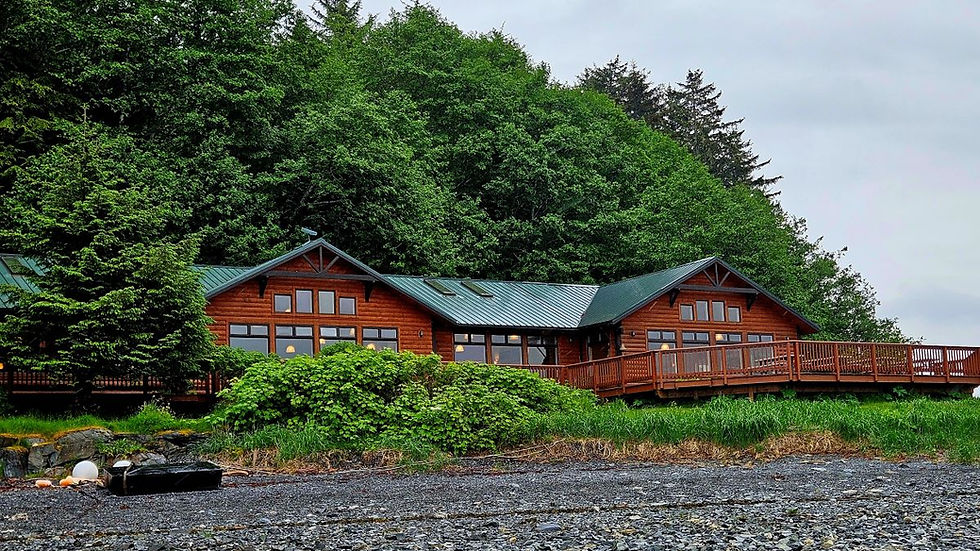 A large log cabin lodge with a gravel-like beach front.