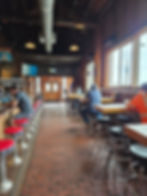 Seattle North Country Diamond Knot Brewery Interior photo. Stools on the left at the bar and tables on the right near the windows.