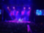 Blue andge purple lights surround the performer on sta