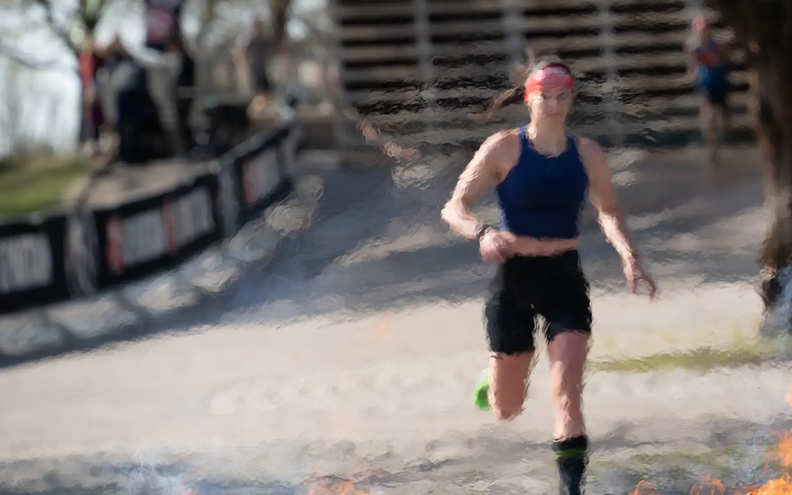 Female runner approaches the fire obstacle at Spartan Race Munich