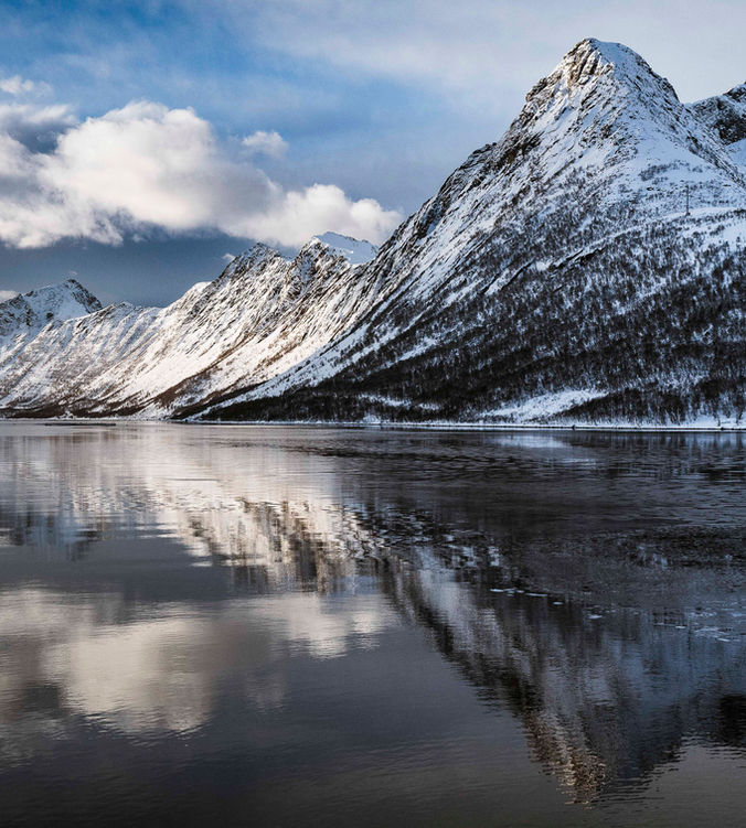 Fjords enneigés avec reflets dans l'eau en Norvège sur l'île de Senja
