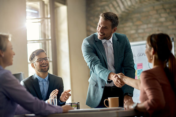 happy-businessmen-greeting-his-colleagues-meeting-shaking-hands-with-one-them-office.jpg