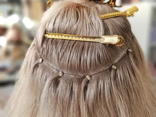 Aanbrengen van NBR hair extensions voor een natuurlijke en volumineuze look, met behulp van zorgvuldig geplaatste beads en technieken.