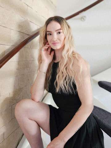 Jonge vrouw in zwarte jurk, poseert op trap