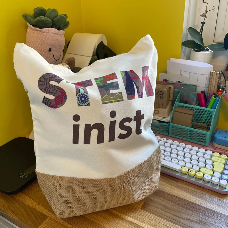 A white tote bag with the word STEMinist on it