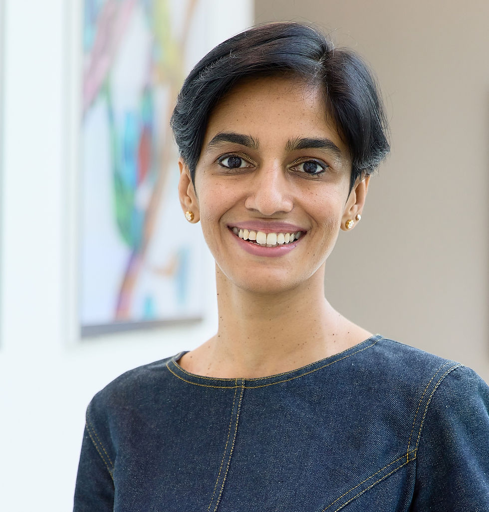 Dr Kanaka Rajan, an indian woman in a blue top, smiling at the camera.