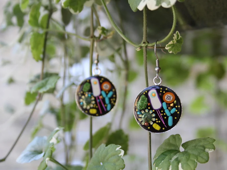 Black earrings designed to look like microbes