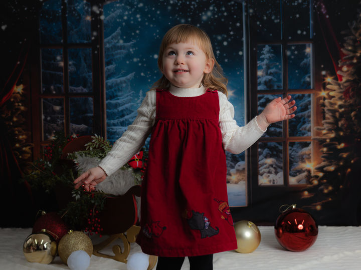 Girl smiling in red holiday dress.