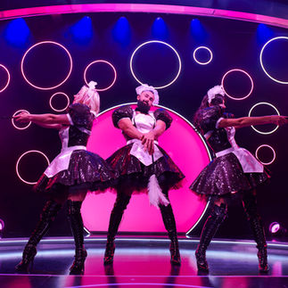 A group on stage in maid outfits